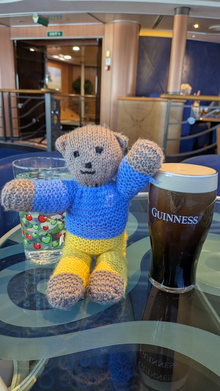 Petya, the knitted bear, beside a pint of Guinness on the ferry